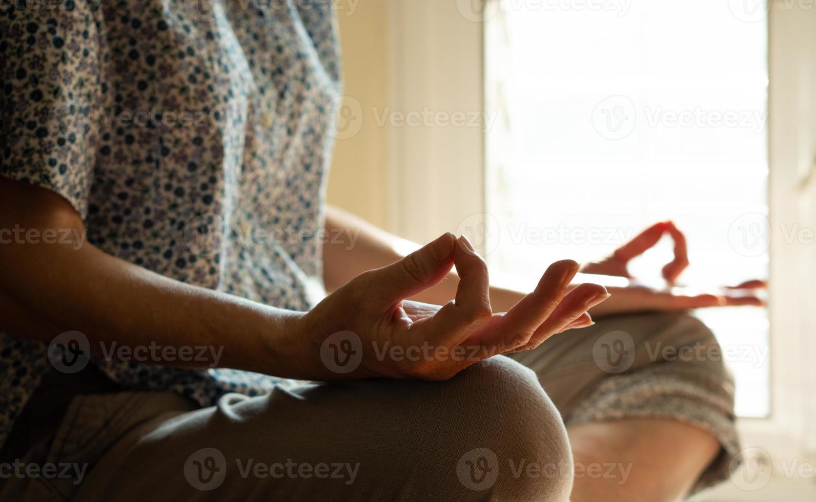 Senior Asian Buddhist woman practicing meditation photo