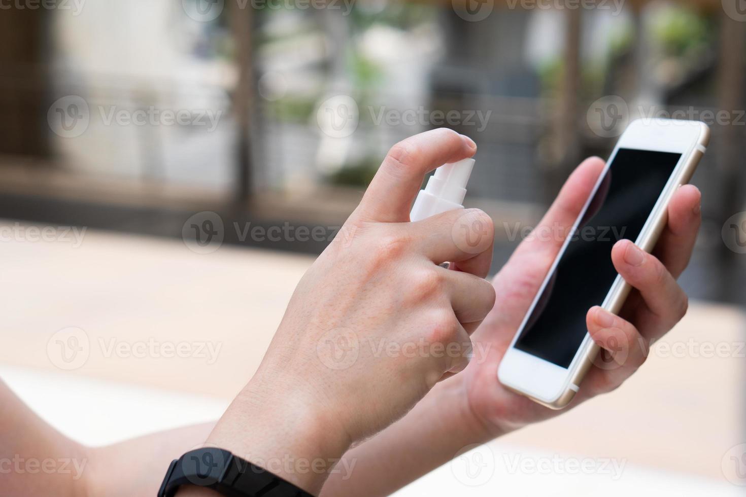 Woman cleaning screen of smart phone photo