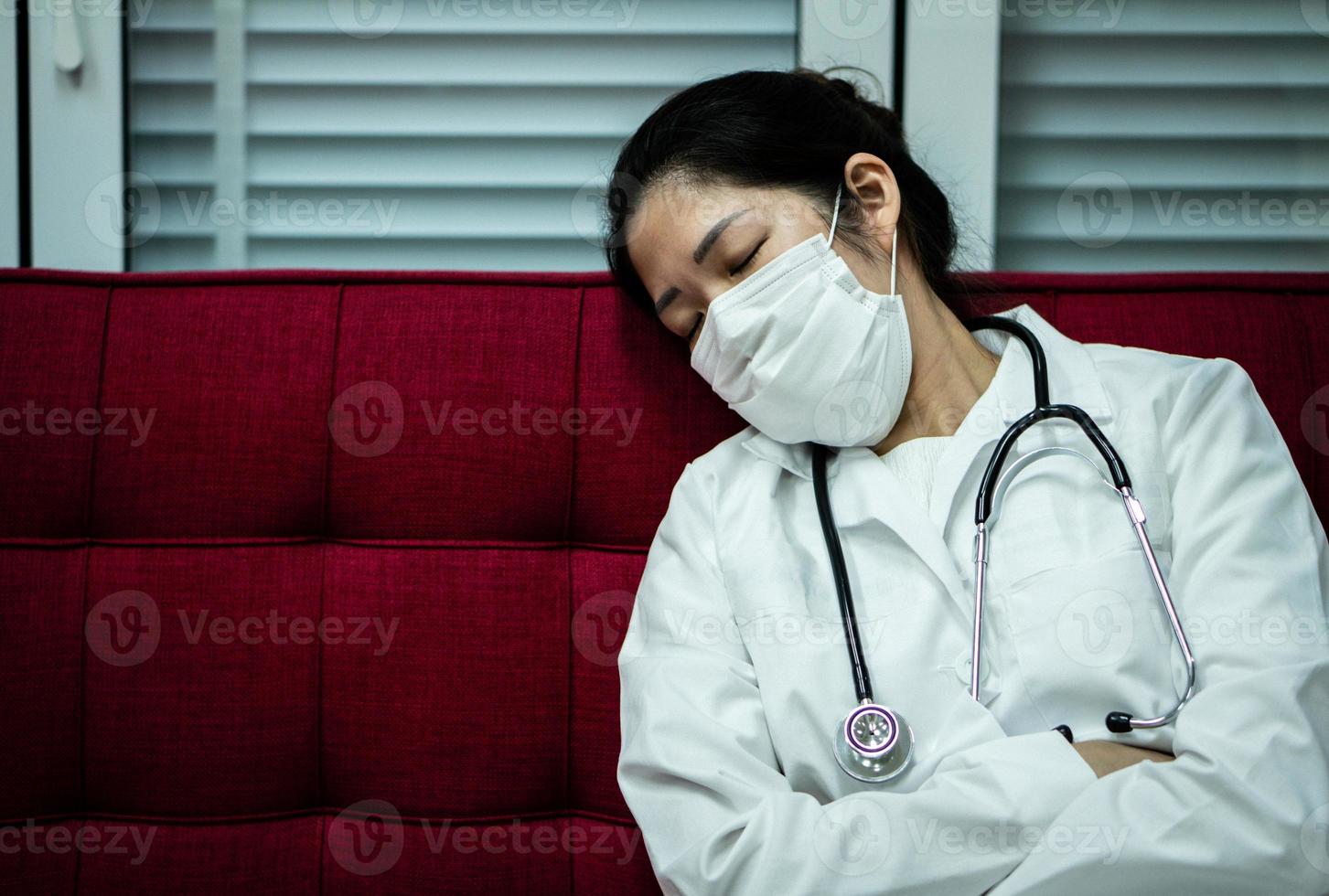 Doctor sleeping on couch wearing mask photo