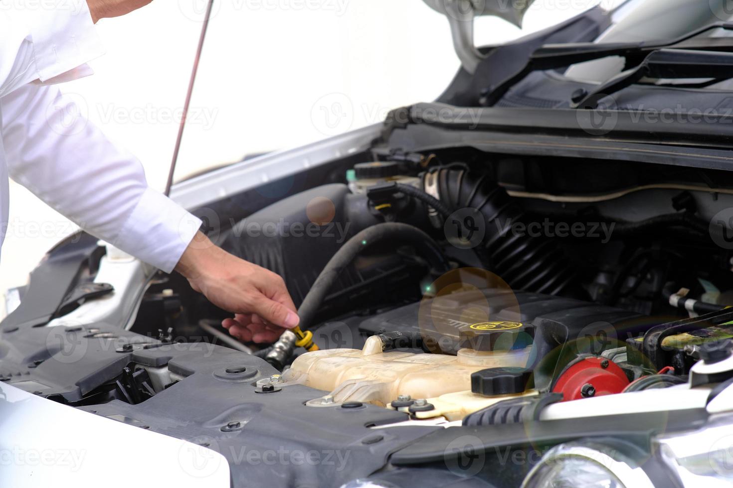 Asian young man sitting on a broken car calling for assistance and repaired wheeled vehicles on the road, Replacing winter and summer tires. Seasonal tire replacement concept photo