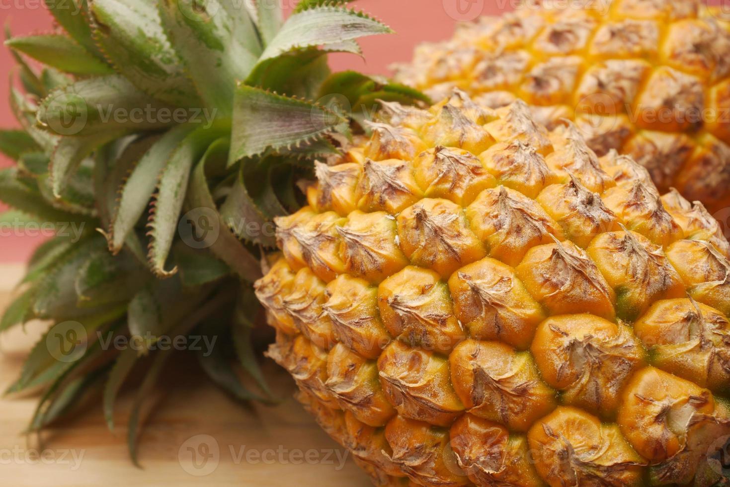 Cerca de piña fresca en un recipiente sobre la mesa foto