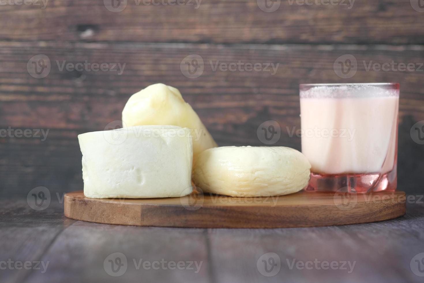 Quesos frescos y vaso de leche en la mesa foto