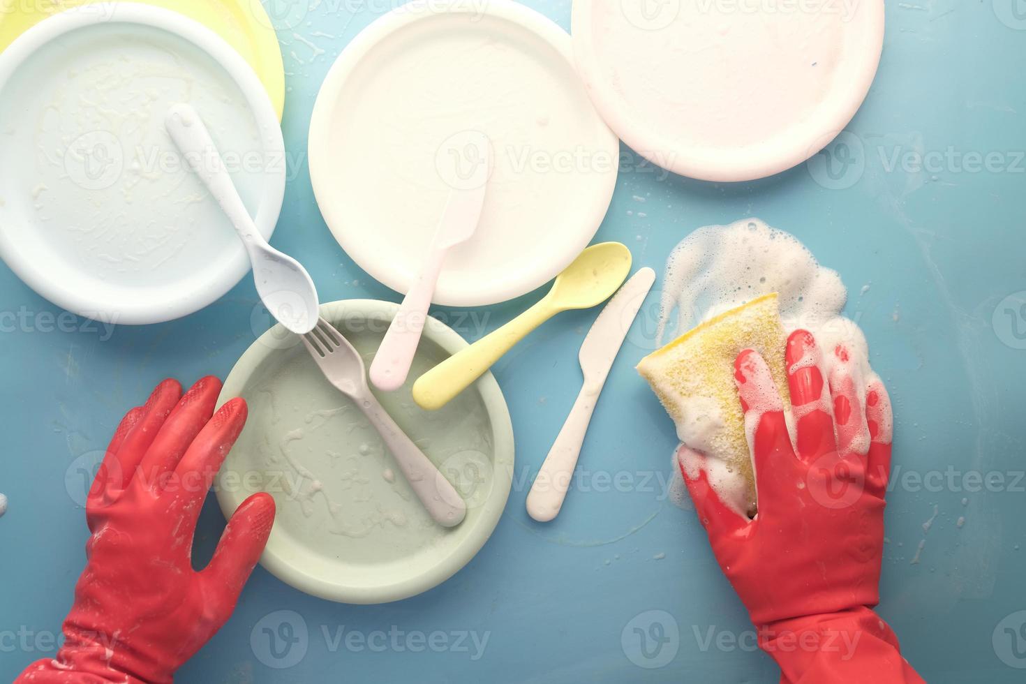 esponja, guantes de goma y placa de colores sobre azul foto