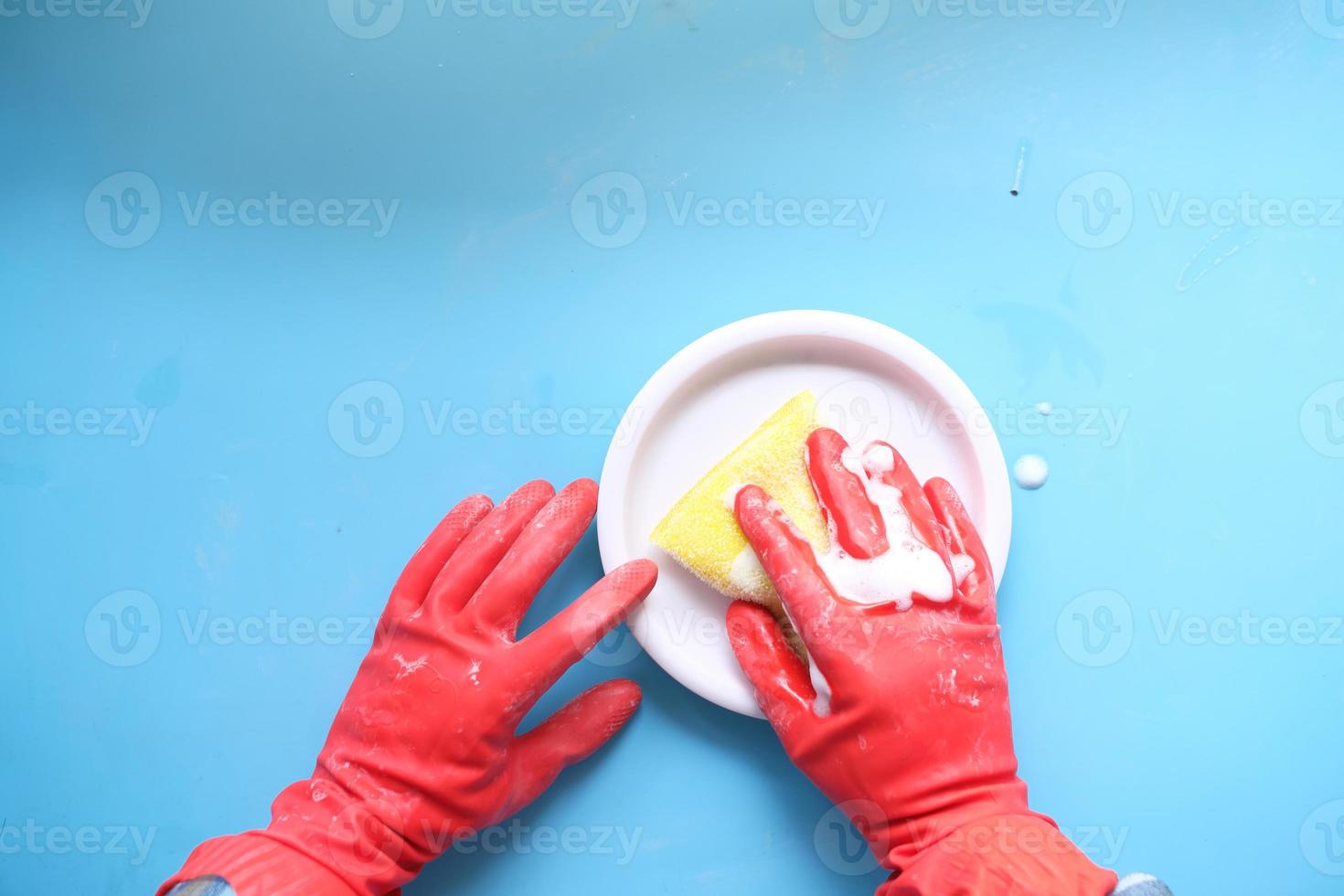 esponja, guantes de goma y placa de colores sobre azul foto