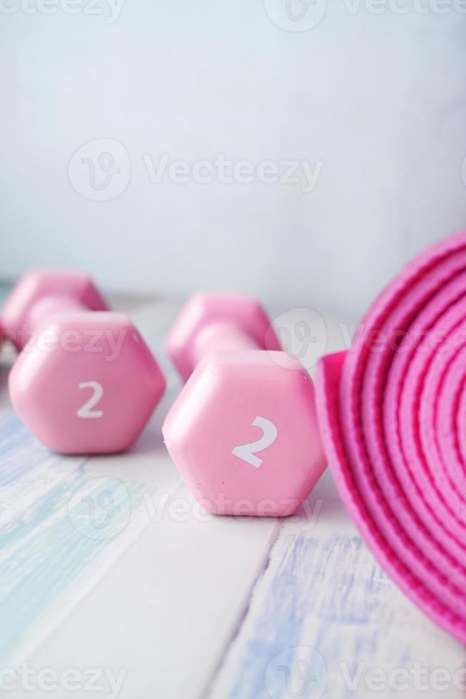 pink color dumbbell, exercise mat and water bottle on white background photo