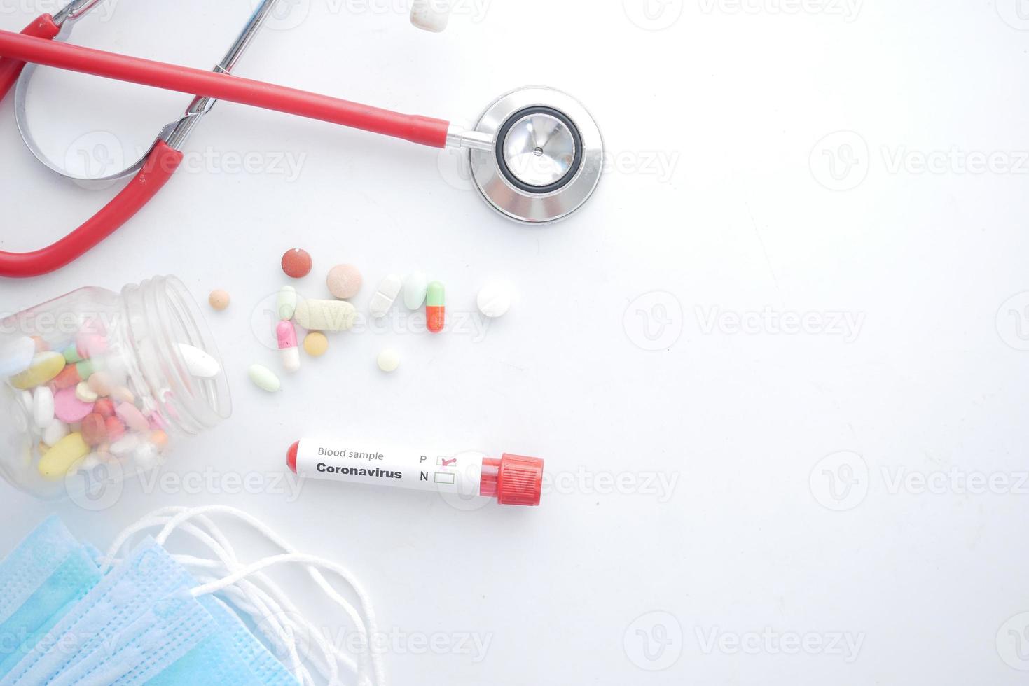 corona virus blood test tube and medical pills on white background photo