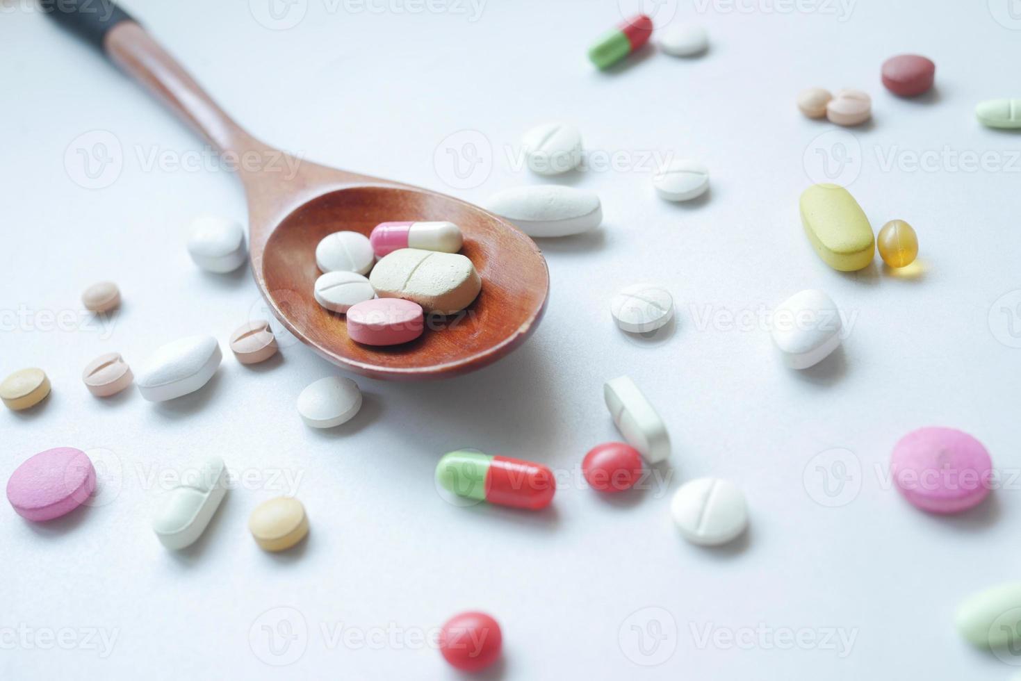 Close up of many colorful pills and capsules on spoon photo