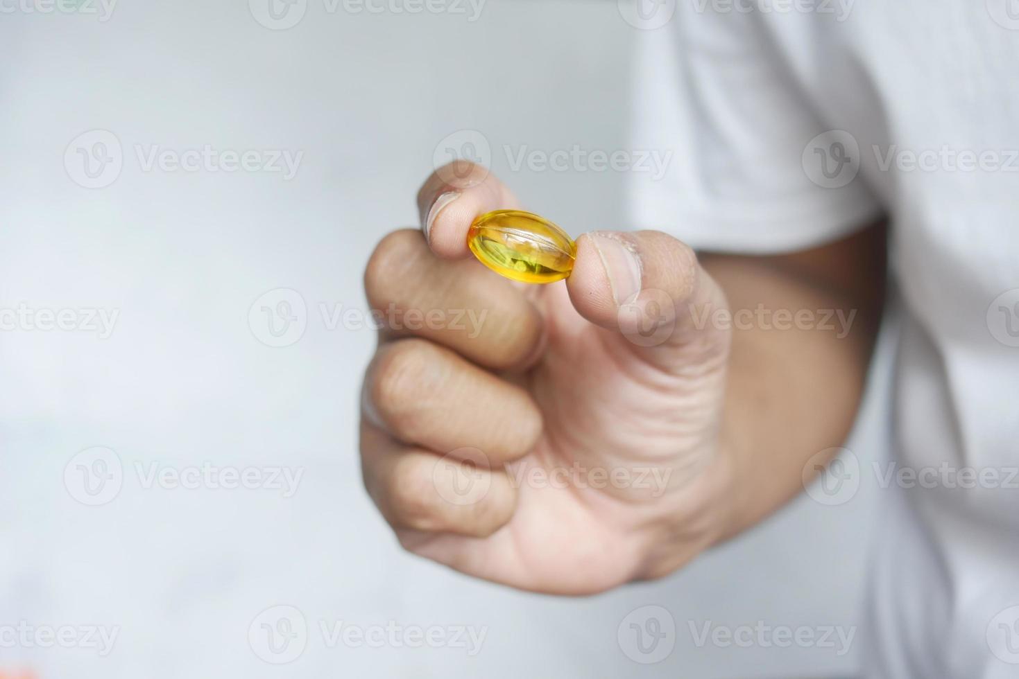 hand holding fish oil supplement close up photo