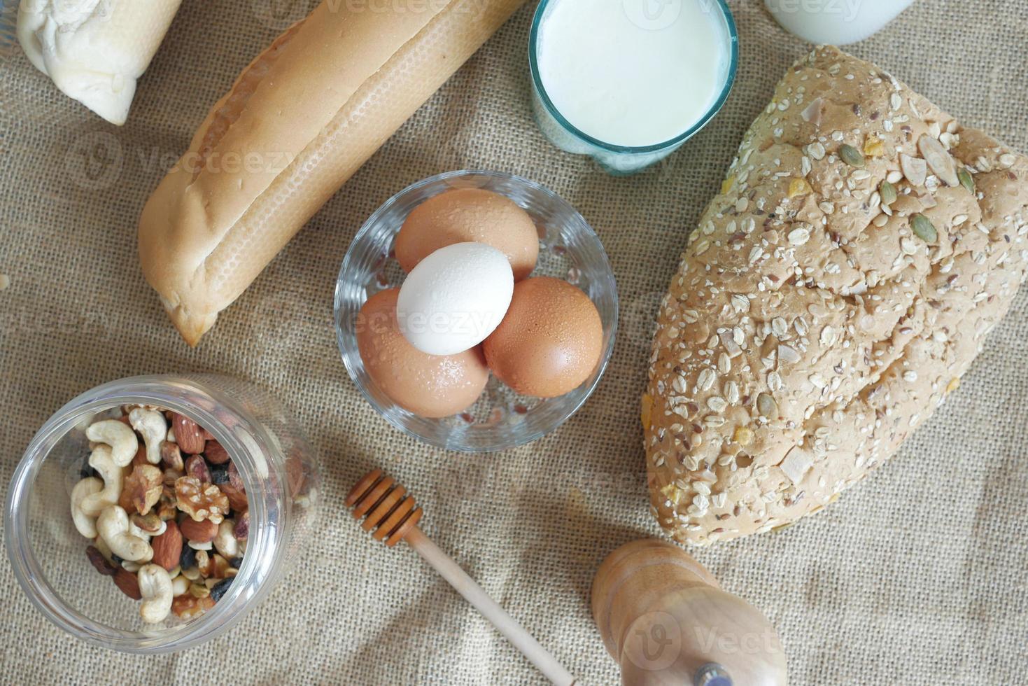 eggs in a bowl, whole meal bread and milk on table photo