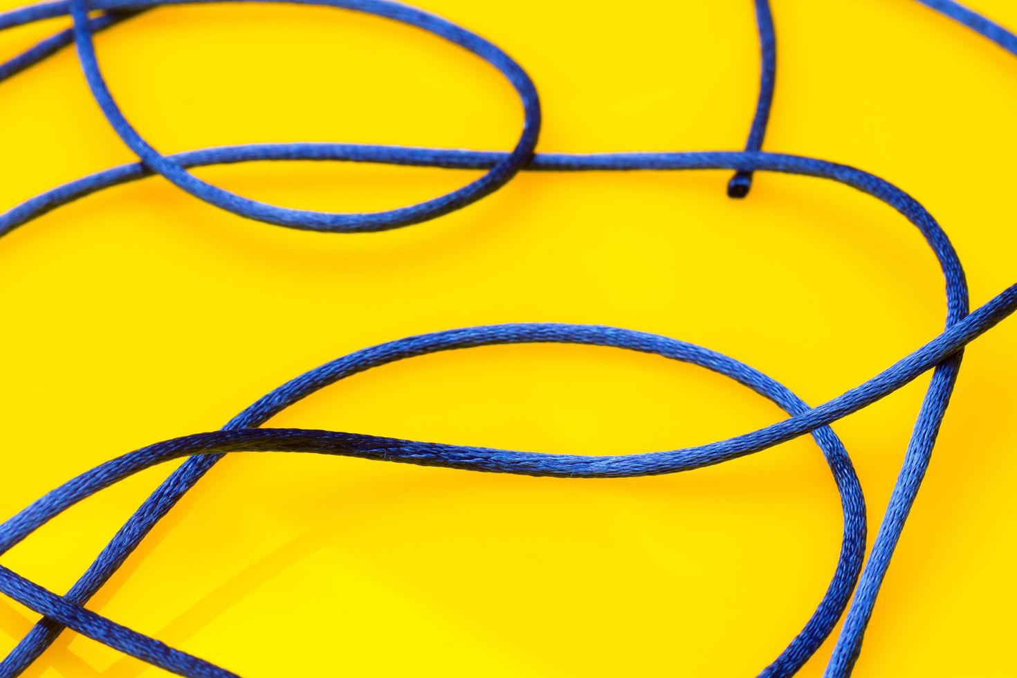 Thin blue string on yellow background photo