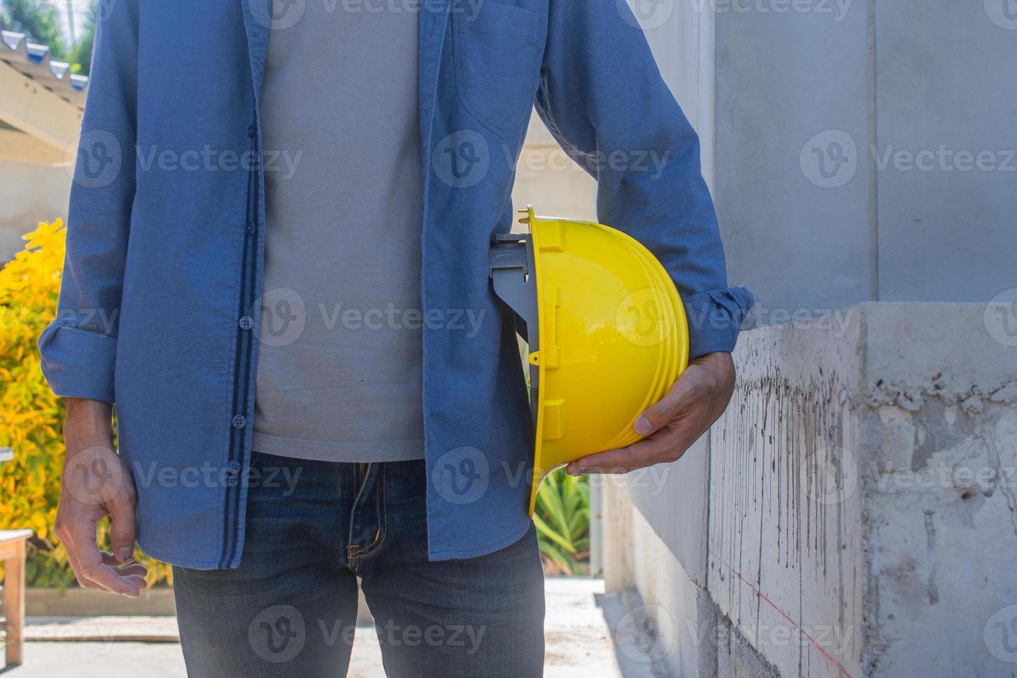 Ingeniero arquitecto arquitecto sosteniendo casco casco trabajando en la construcción del sitio foto