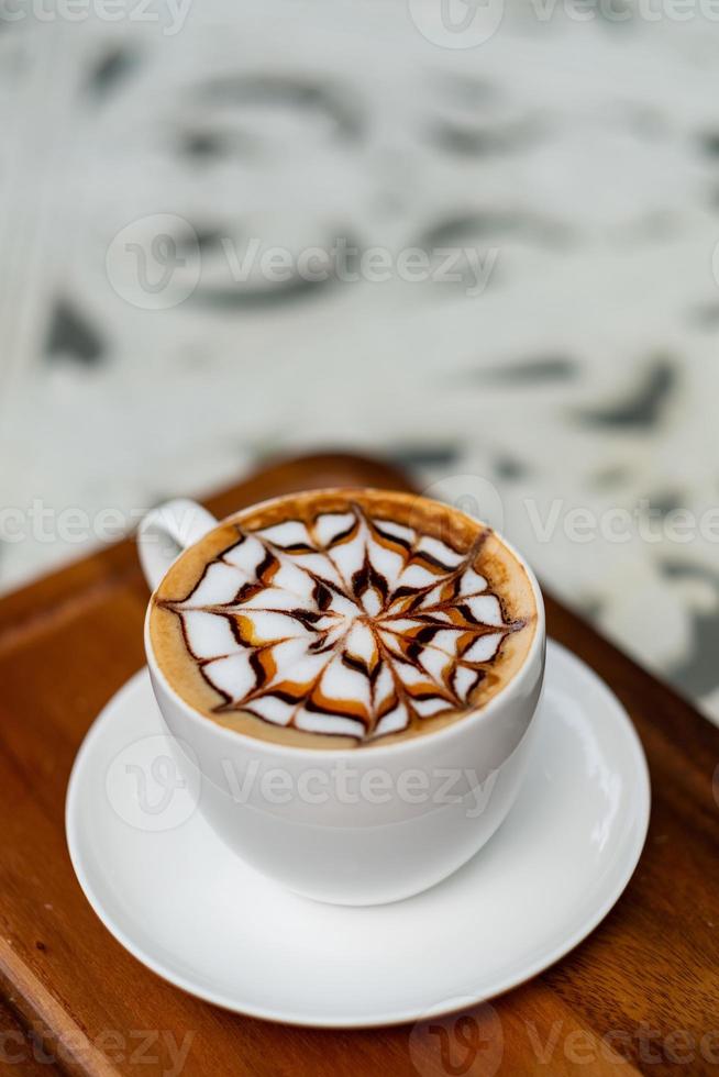 Hot latte art coffee on wood table, relax time photo