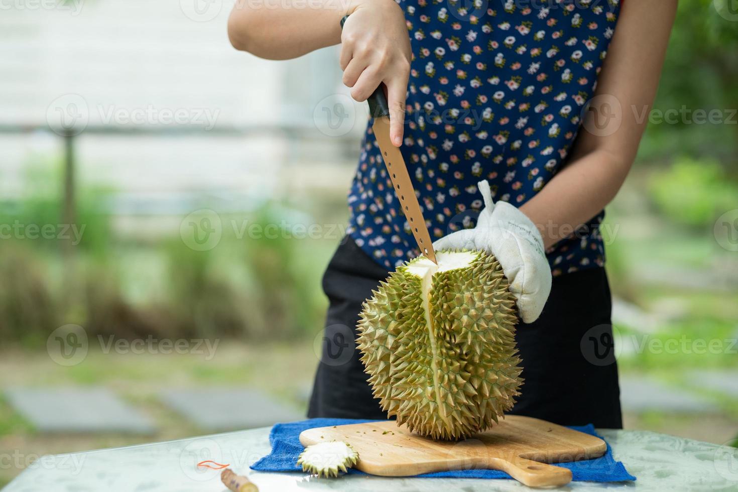 Primer plano mujer pelando la mano durian, rey de la fruta foto