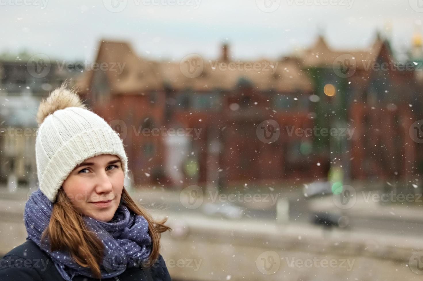 Retrato de una joven hermosa niña sonriente feliz en el fondo de la ciudad foto