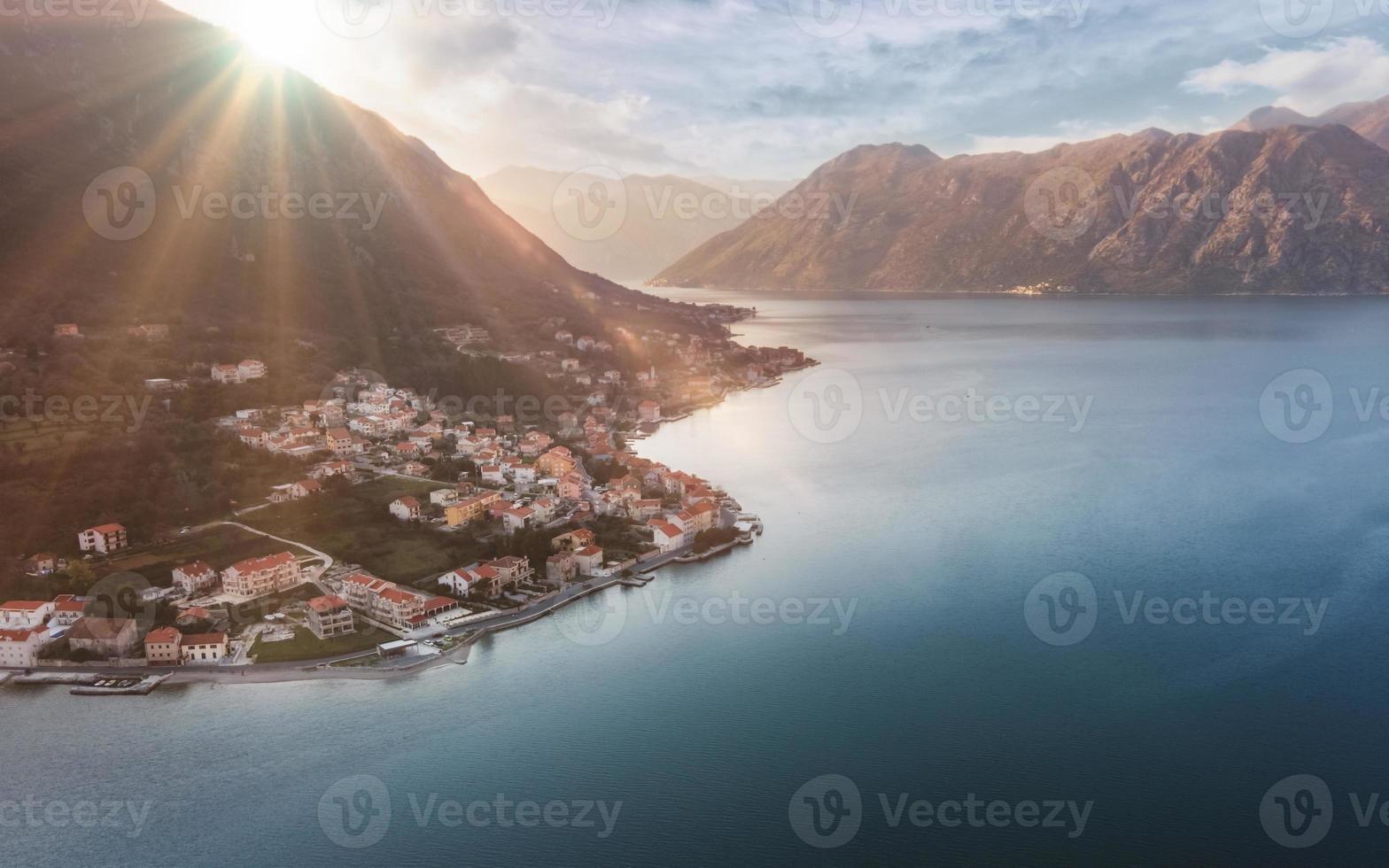 Vista aérea de la ciudad de Prcanj en la bahía de Kotor al atardecer, sol sobre la ciudad de Montenegro foto