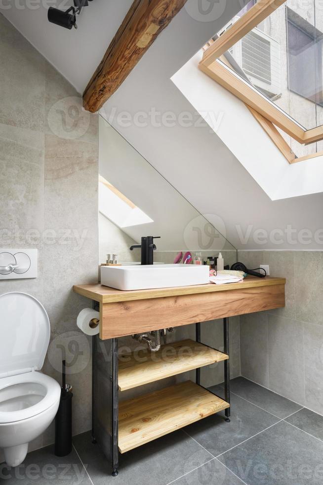 ático, baño moderno, diseño interior del apartamento con viejas vigas y muebles de madera rústica, elegante cerámica italiana de granito. foto