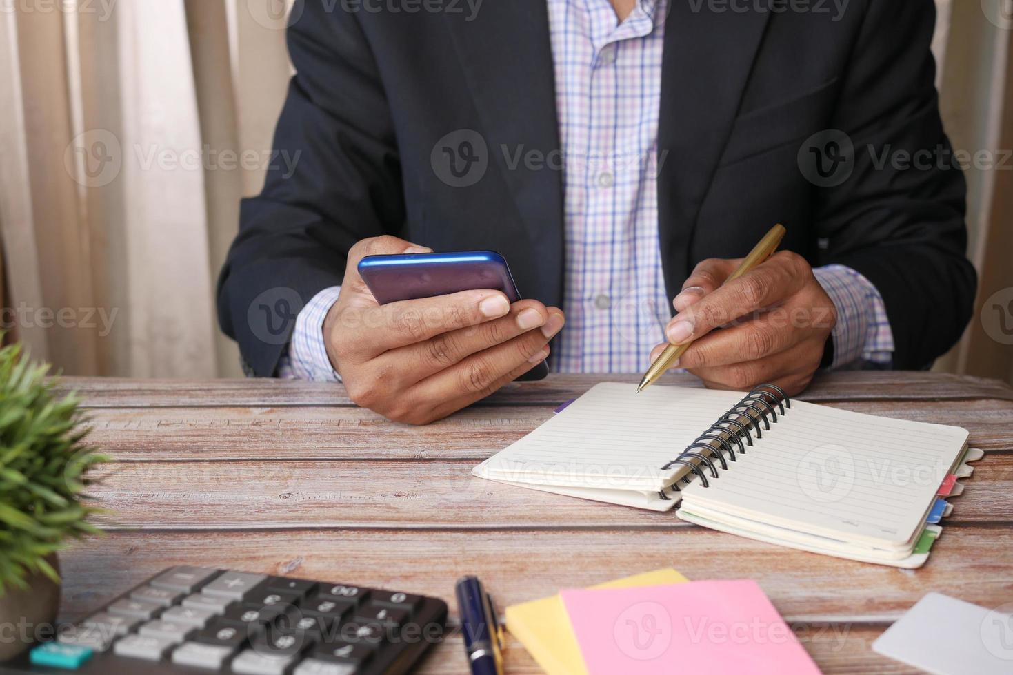 joven con smartphone y escribiendo en el bloc de notas foto