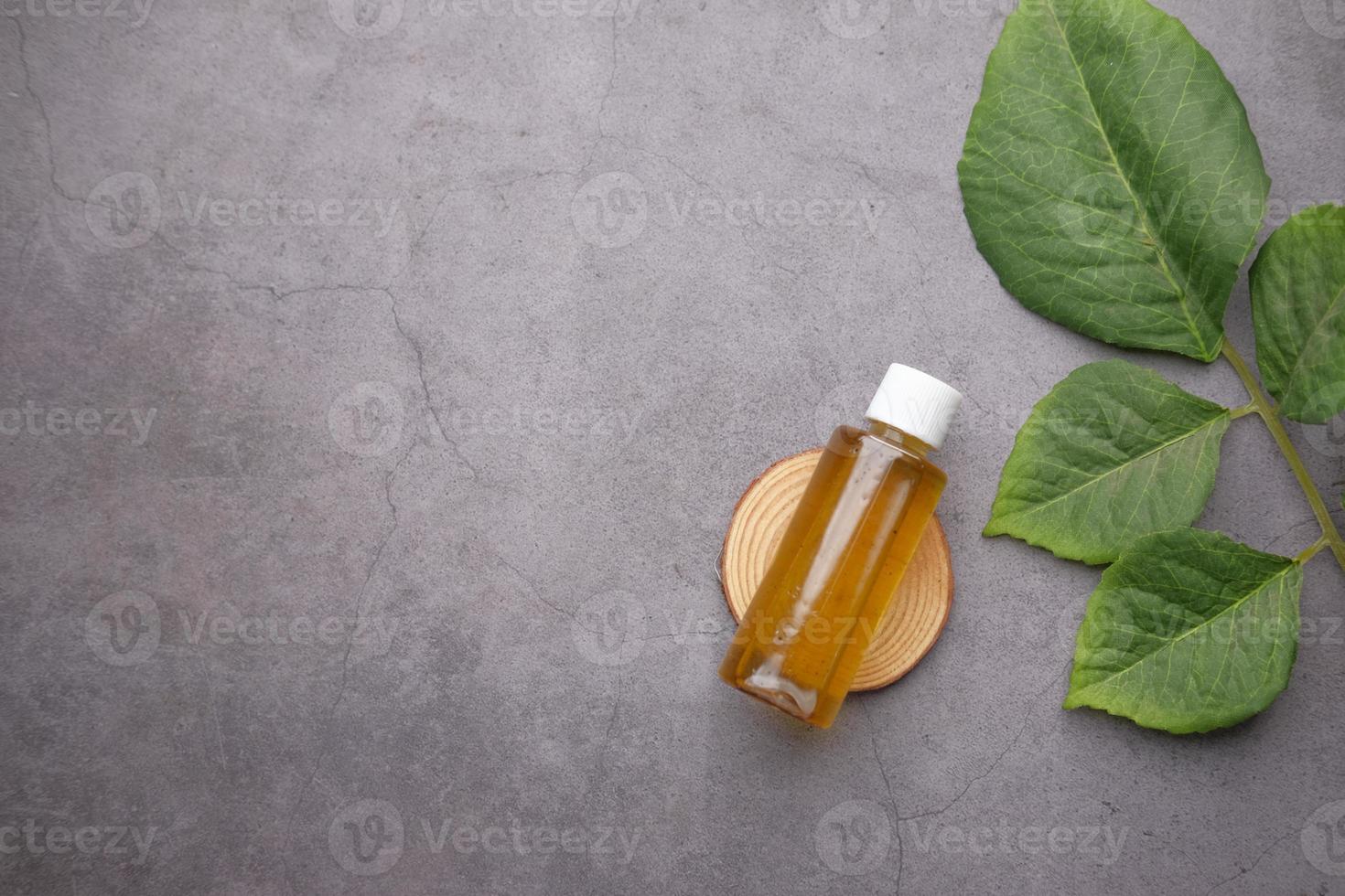 Eucalyptus essential oils in a glass bottle with green leaf on dark background photo