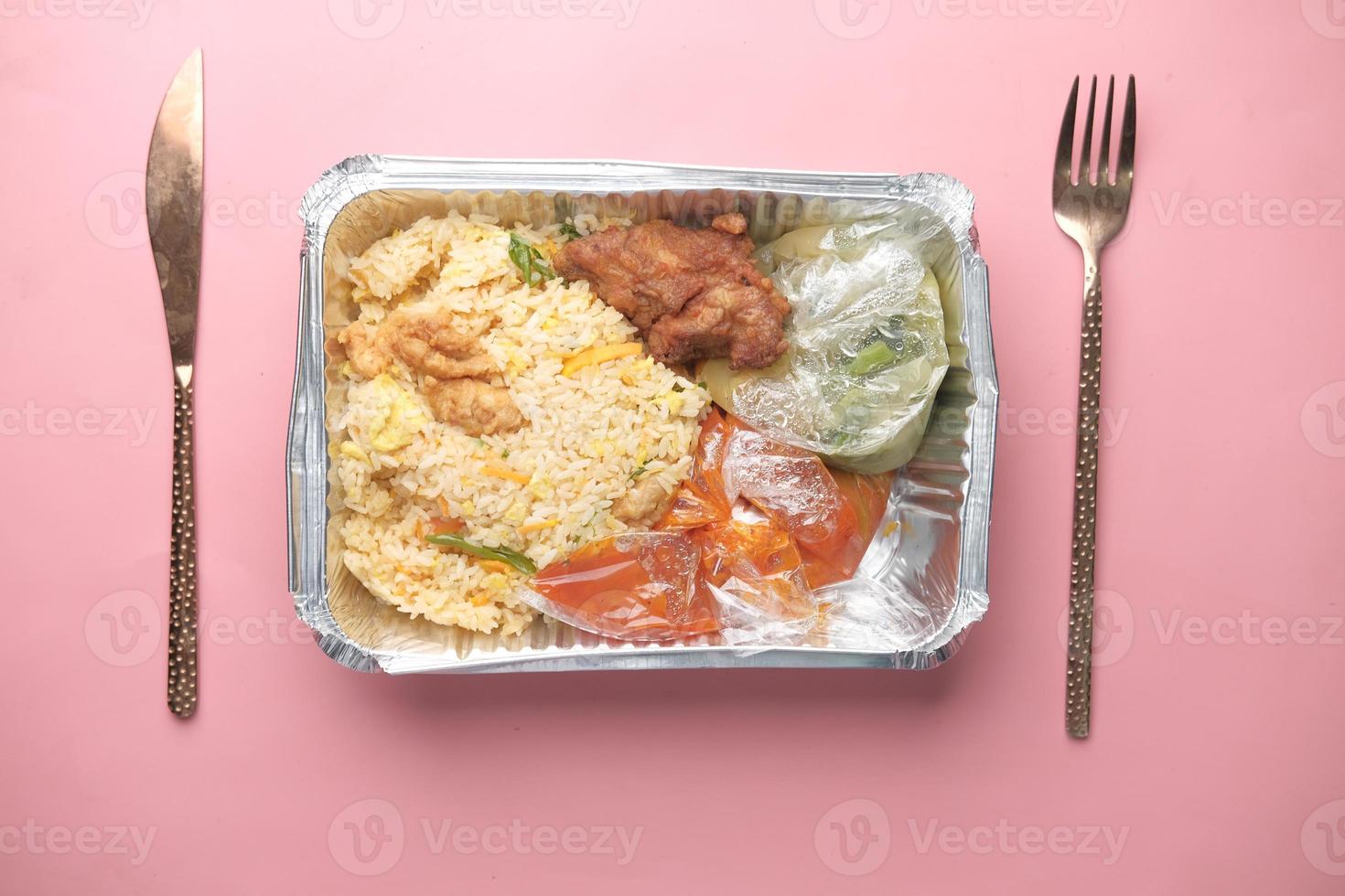 Chicken biryani meal in a takeaway box on table photo