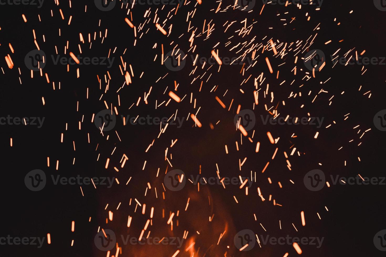 close up of sparks from fire, sparks on black background, extravaganza of fire, magic with sparks. photo