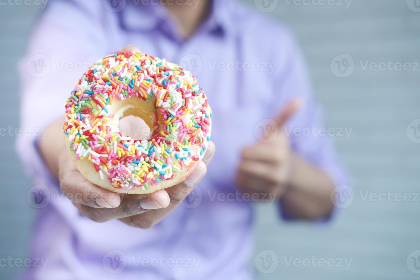 Close up of hand holding a donut photo