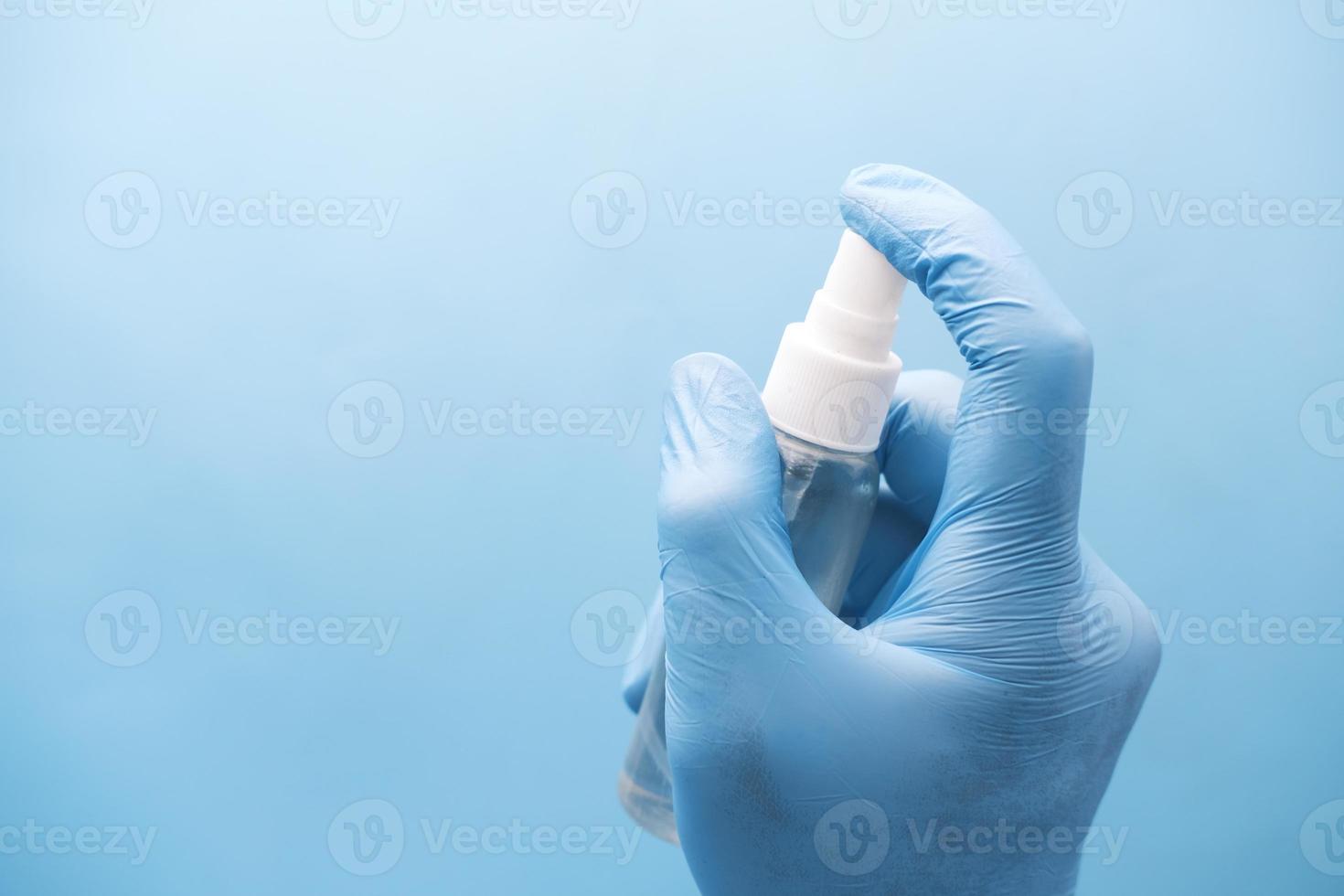 Close up of young man's hand using hand sanitizer spray photo