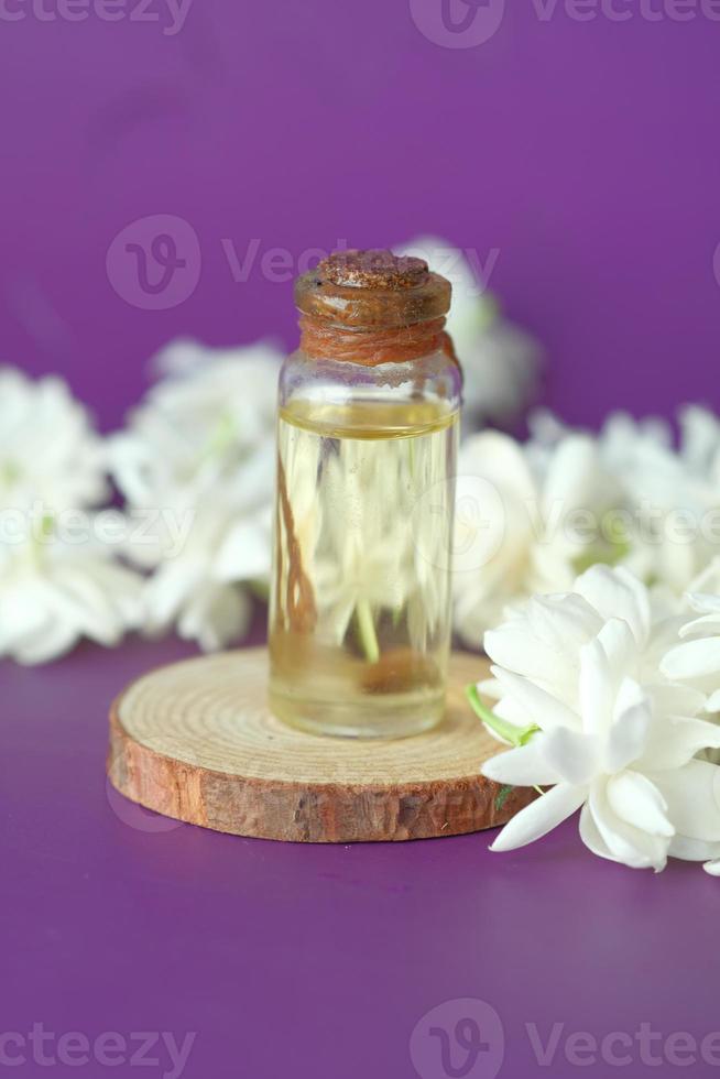 Eucalyptus essential oils in a glass bottle and flower on purple background photo