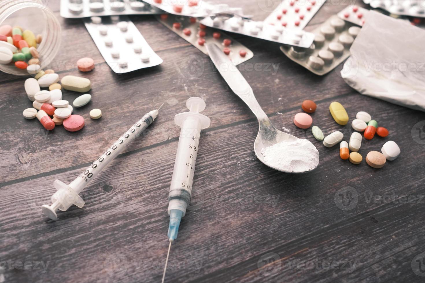 Drug addiction concept with heroine packet and syringe on black background photo