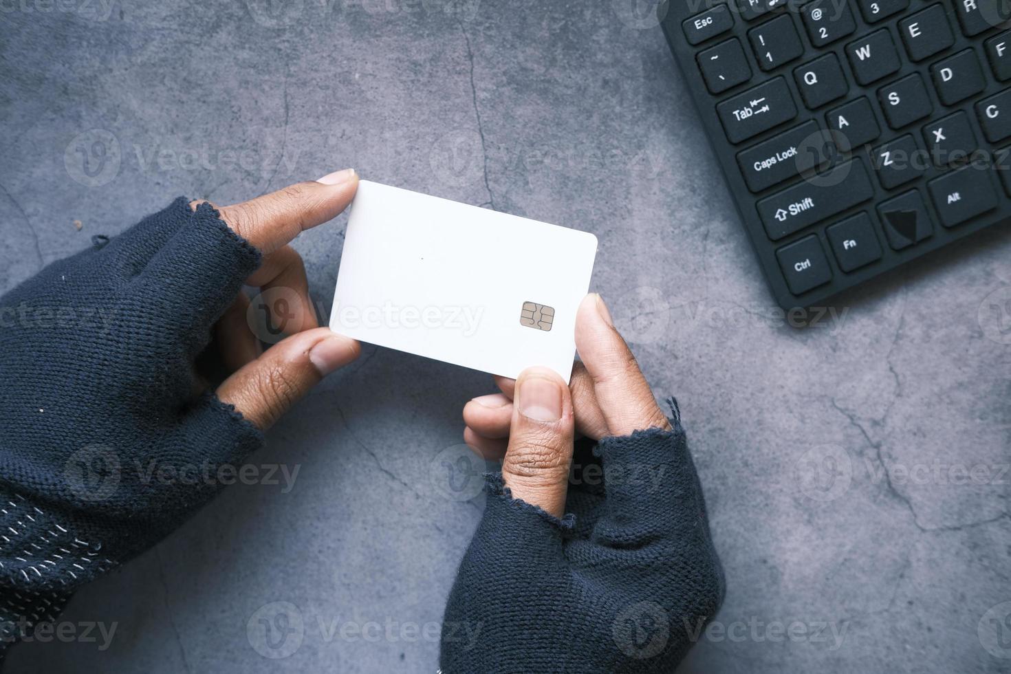 Hacker's hand stealing data from credit card photo