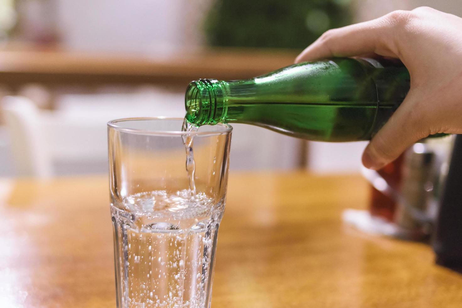 Pouring mineral water into the glass photo