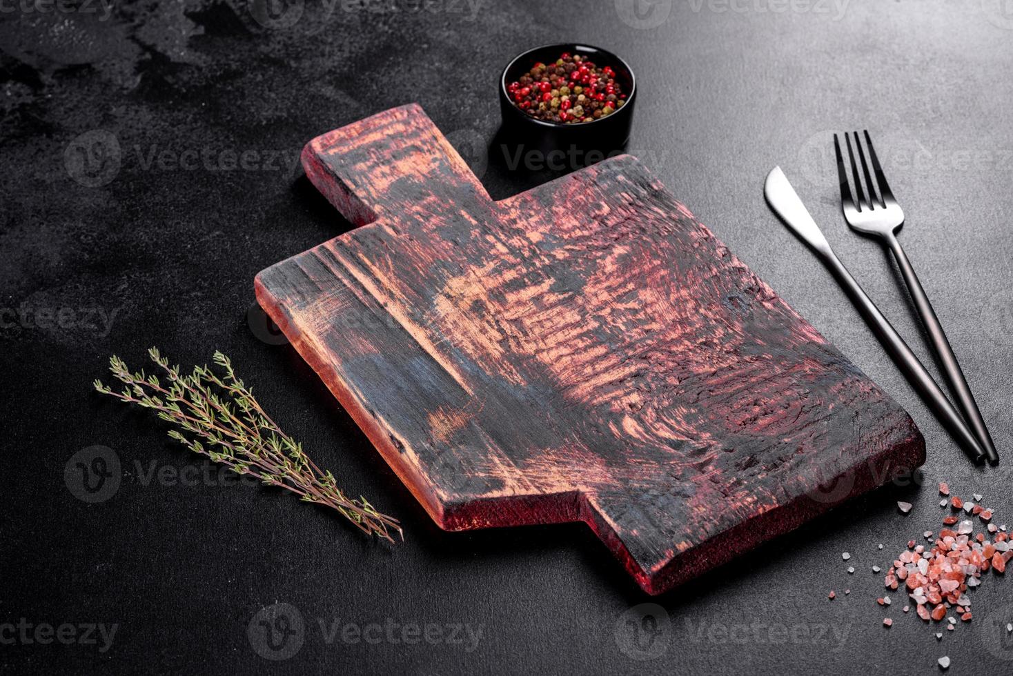 cortar tabla de madera, verduras y una mesa oscura especial foto