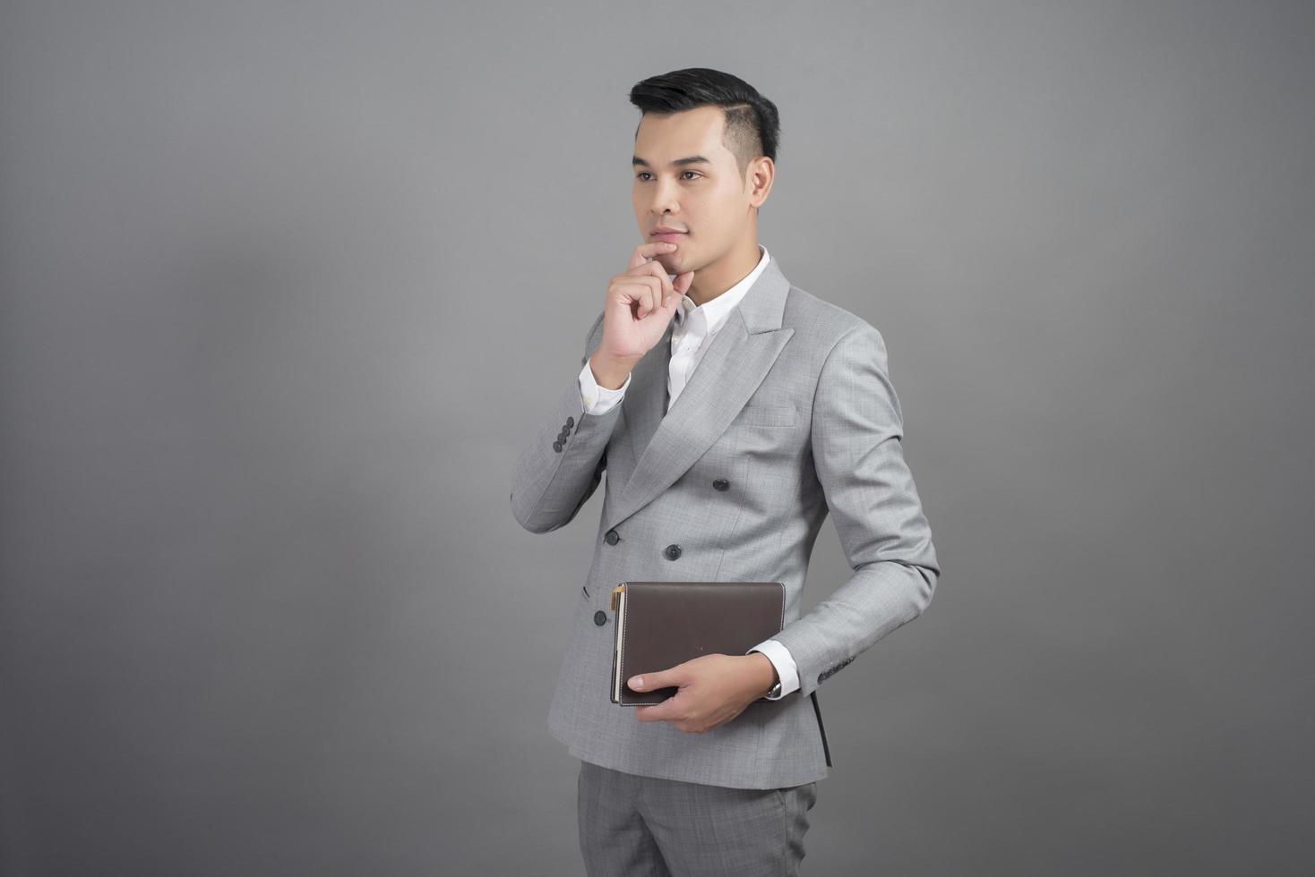 Businessman is thinking, portrait in studio grey background photo