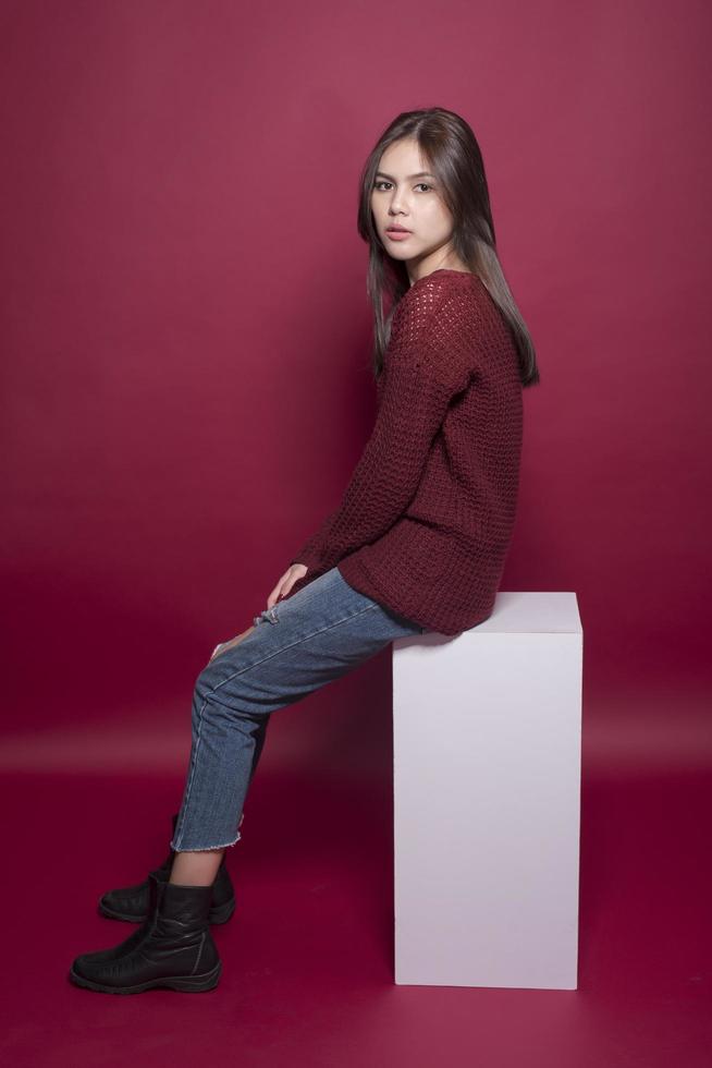 Beautiful woman portrait in studio on red background photo