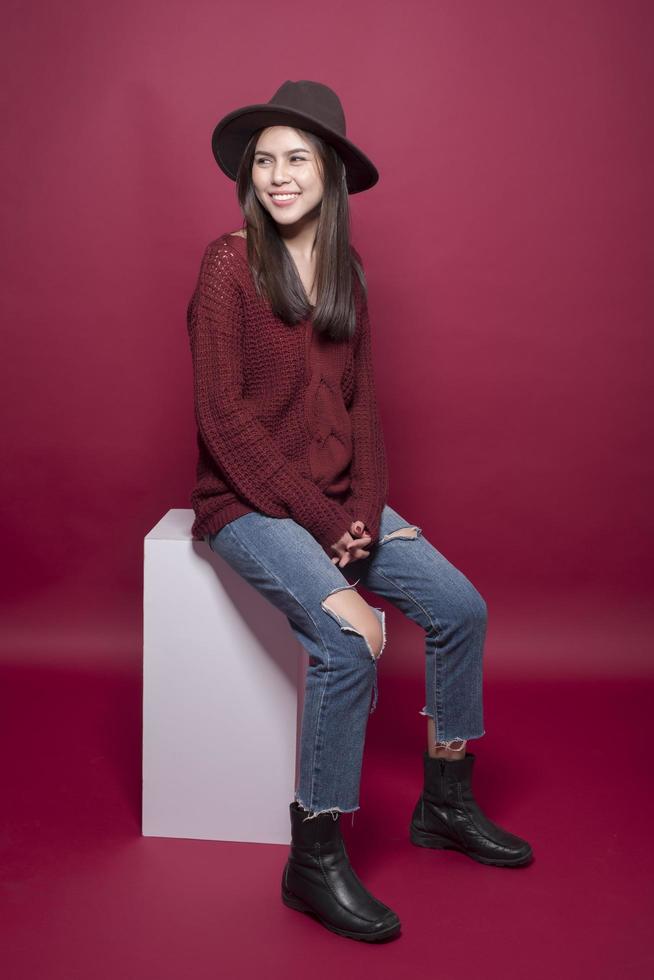 Retrato de mujer hermosa en estudio sobre fondo rojo. foto