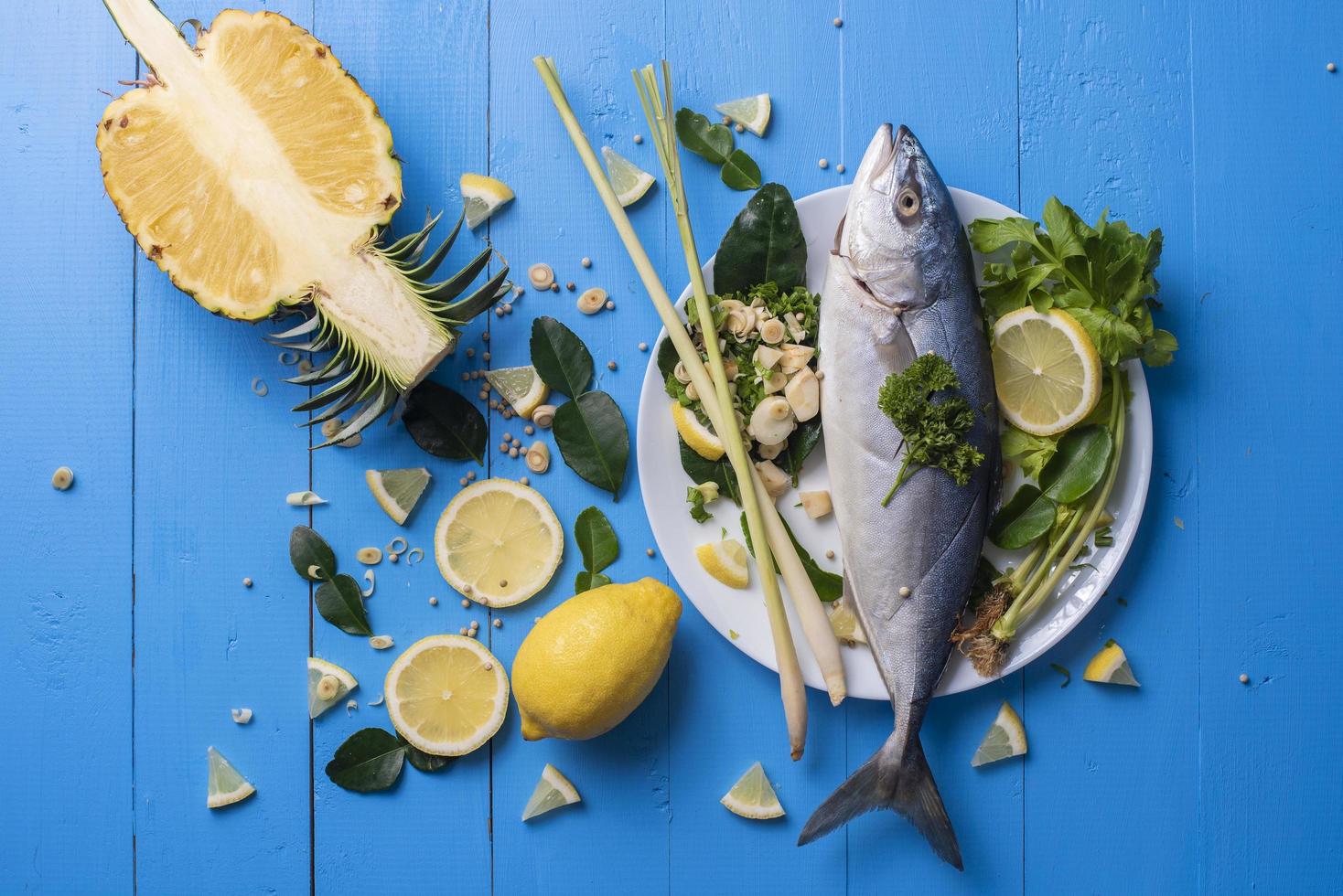 Fish food with ingredient spices on blue table photo