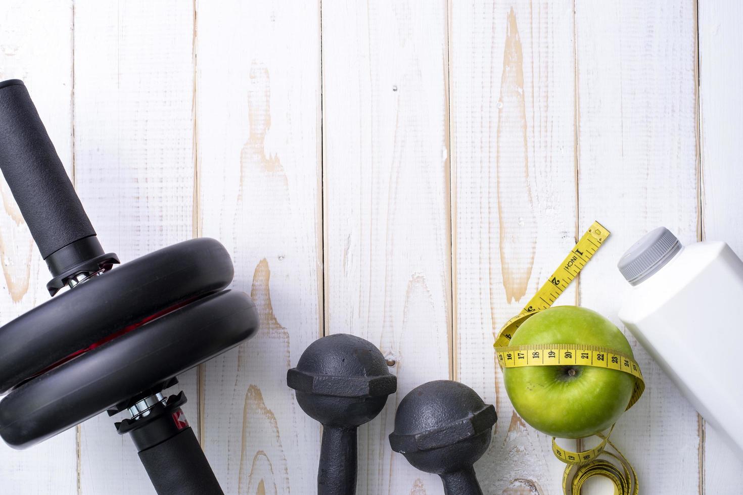 Fitness equipment and Health food on white  wooden background photo