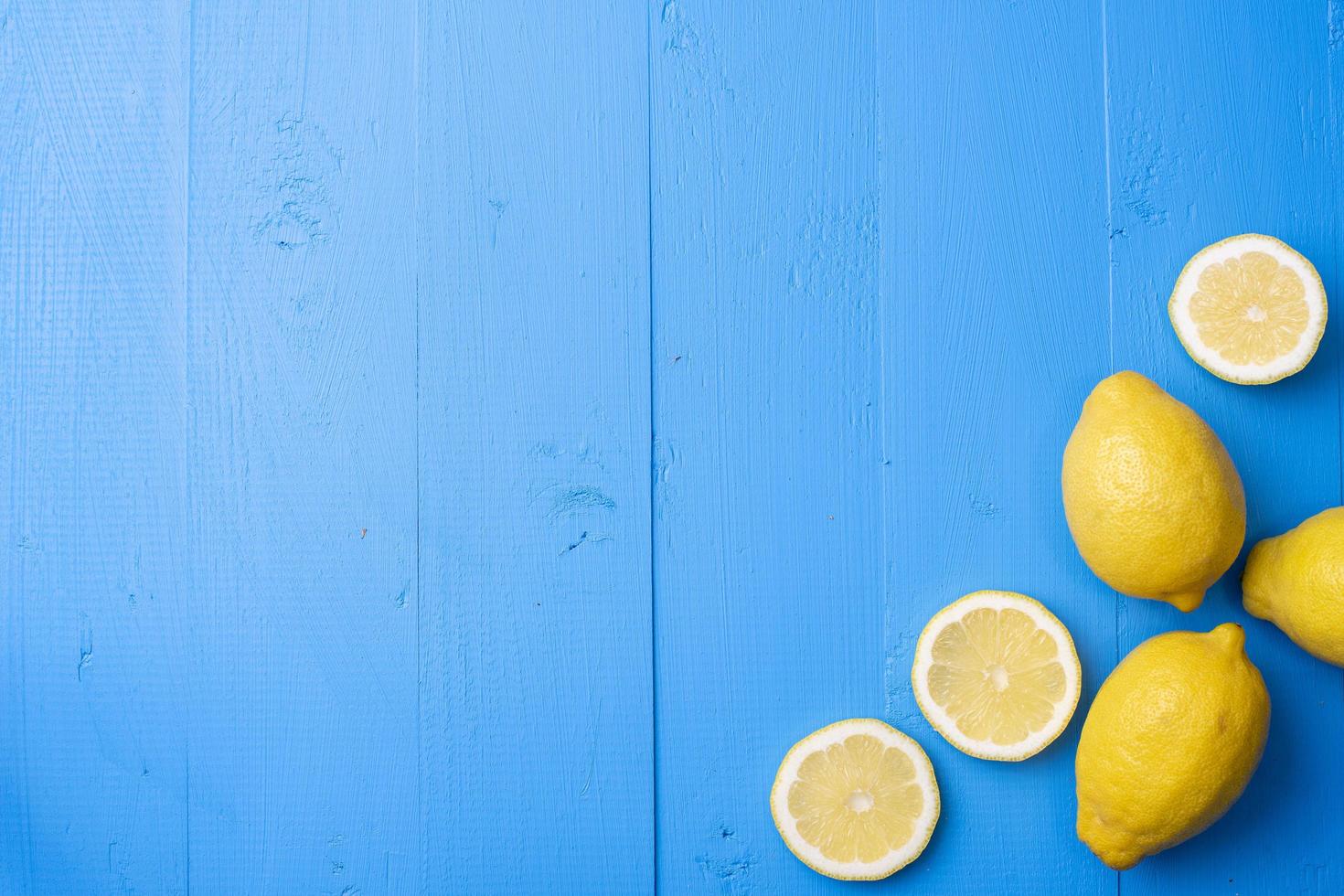 Yellow lemon on blue wooden background photo