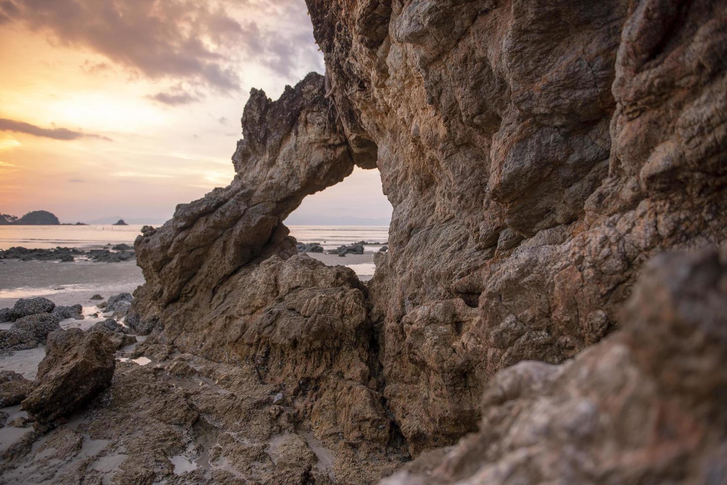 Beautiful rock on beach at sunset photo