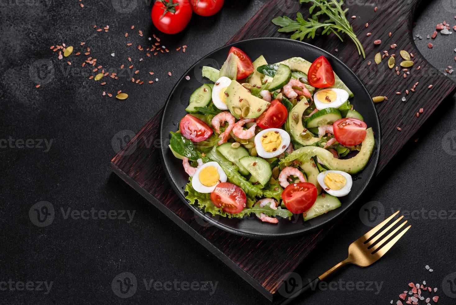 Salad with shrimp, avocado, cucumber, pumpkin seeds and flax seeds with olive oil photo