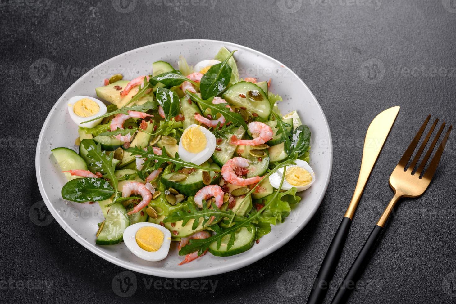 Salad with shrimp, avocado, cucumber, pumpkin seeds and flax seeds with olive oil photo