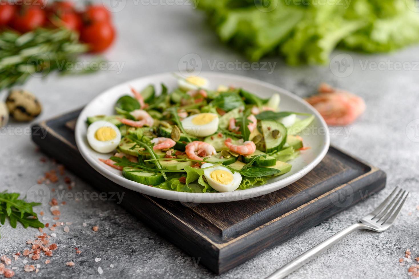 Salad with shrimp, avocado, cucumber, pumpkin seeds and flax seeds with olive oil photo