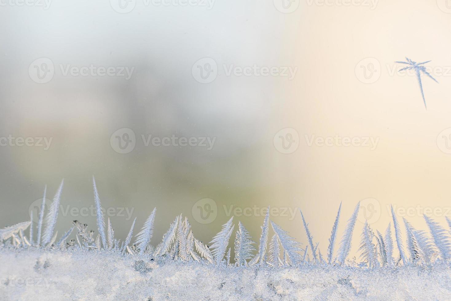 Frost patterns on the glass of the winter window in freezing cold weather photo