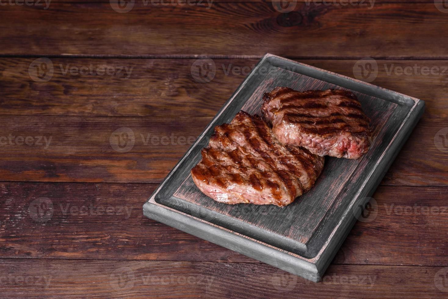 Fresh juicy delicious beef steak on a dark background photo