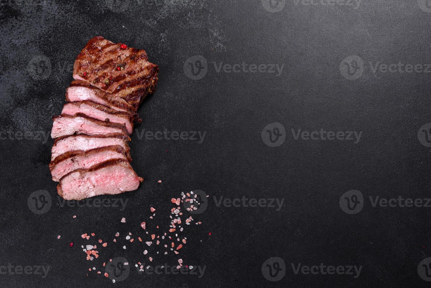Fresh juicy delicious beef steak on a dark background photo