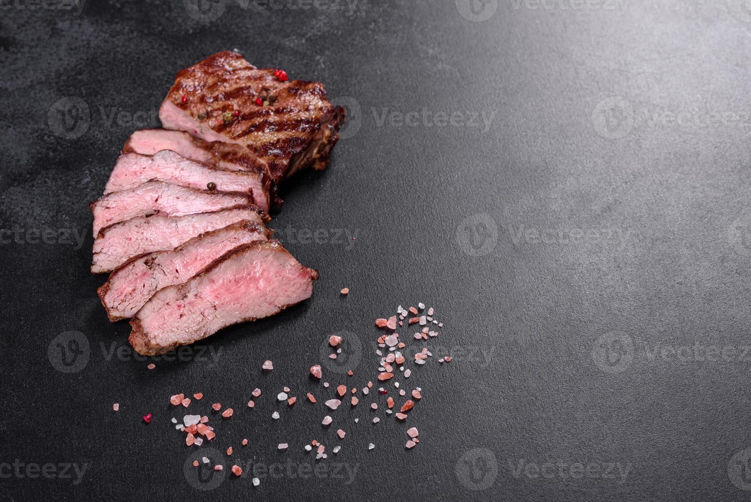 Fresh juicy delicious beef steak on a dark background photo