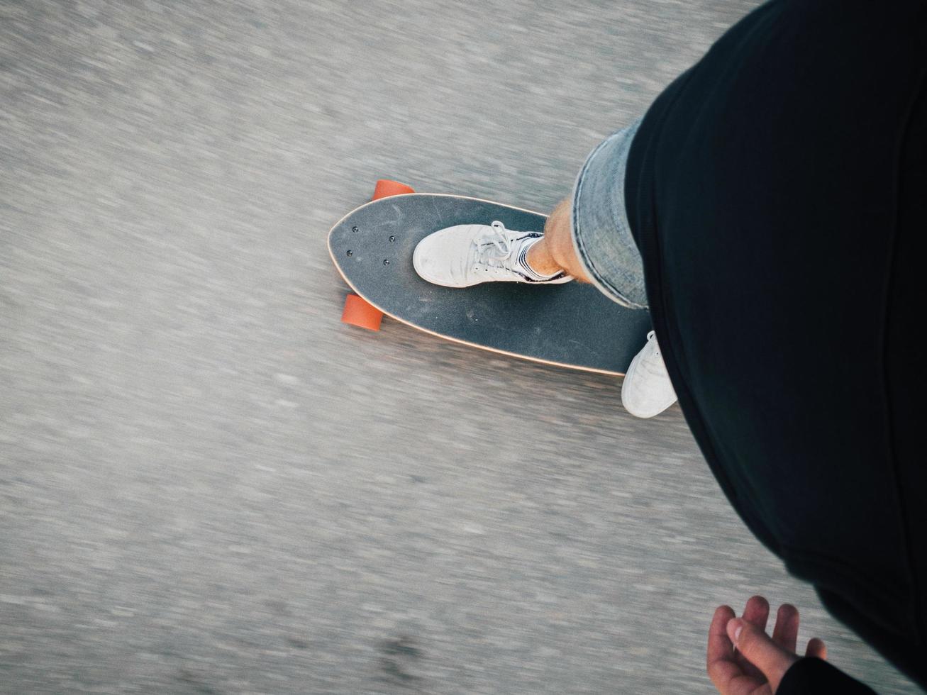 persona montando patineta, vista de arriba hacia abajo foto