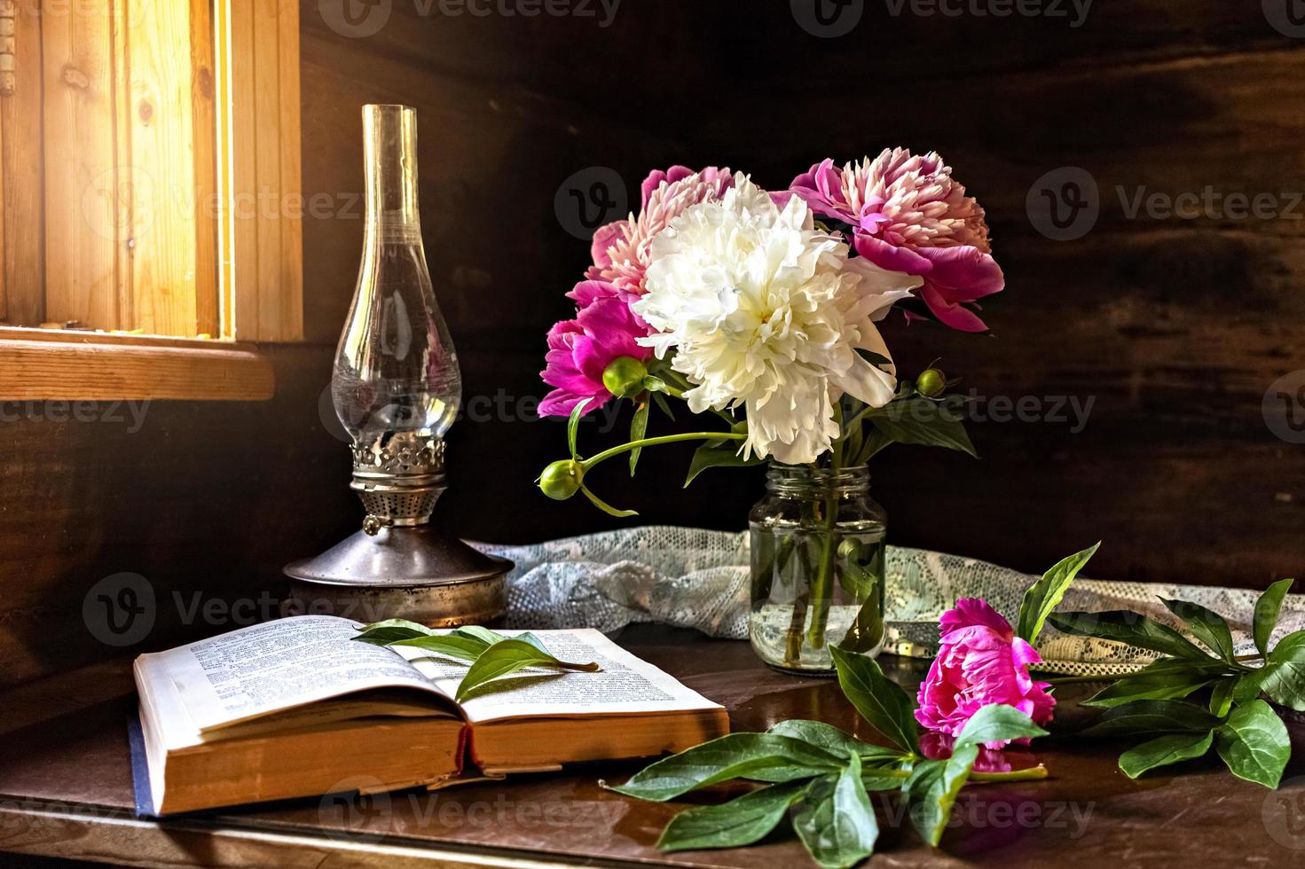 Bodegón de artículos vintage y un ramo de peonías en una mesa foto