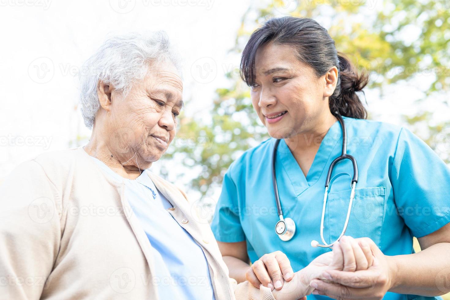 médico ayuda y cuidado anciana asiática mayor o anciana caminando en el parque en felices vacaciones frescas. foto