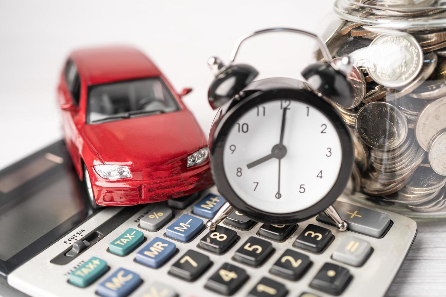 Car and alarm clock on coins, Car loan, Finance, saving money, insurance and leasing time concepts. photo
