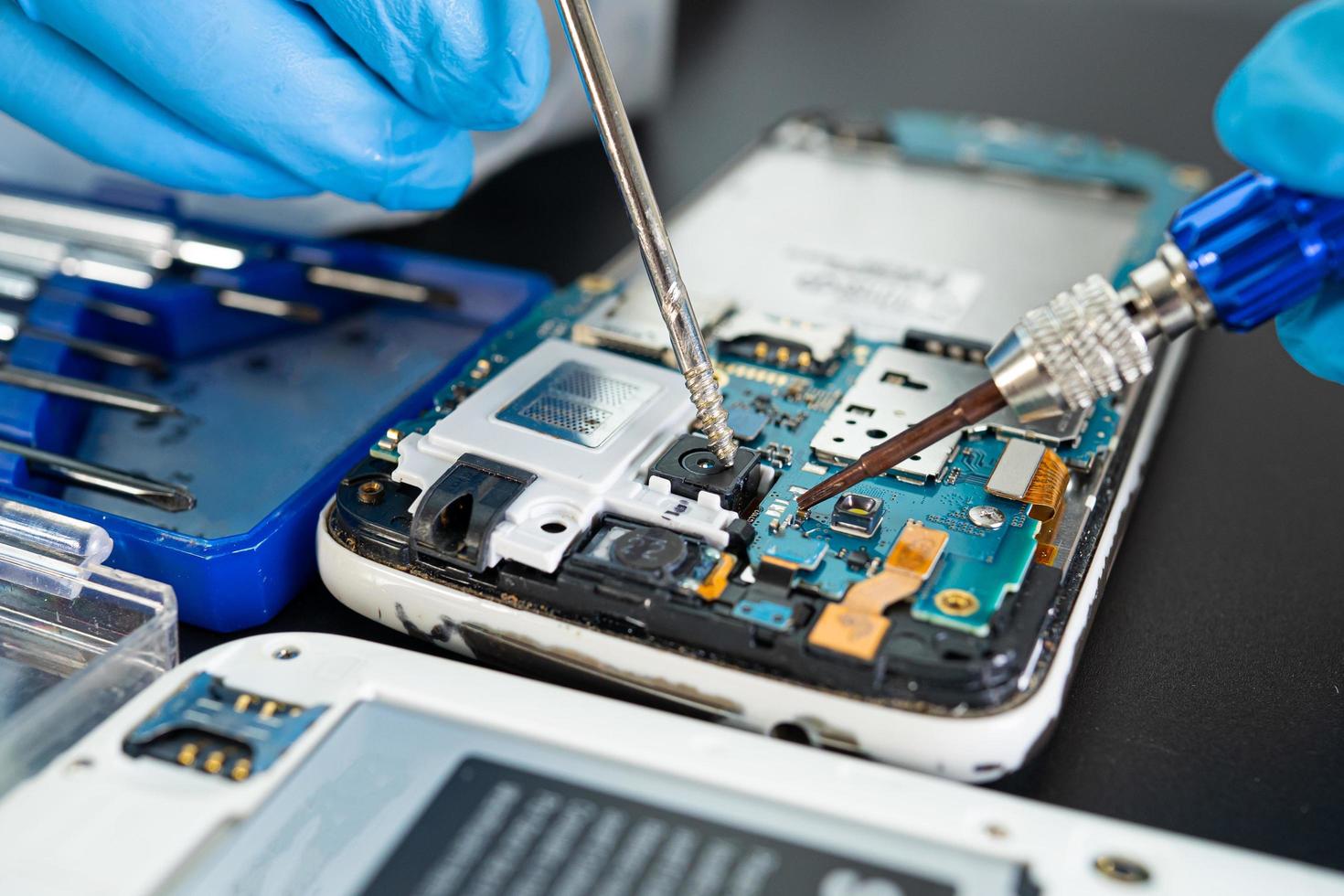 Technician repairing inside of mobile phone by soldering iron. Integrated Circuit. the concept of data, hardware, technology. photo